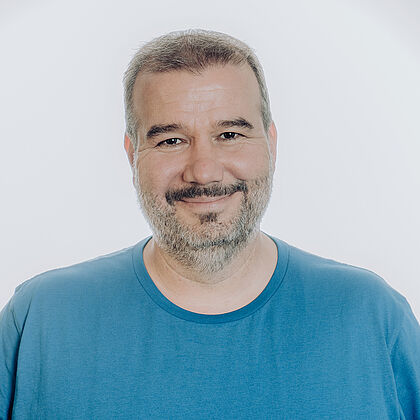 Ein Mann mit Bart lächelt in die Kamera.